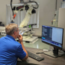 Dispensing robot operator configuring bead inspection software on a computer screen