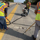 Worker applying sealant with the GMP 025-C system to repair a long crack in a bridge roadway surface.