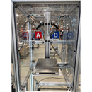 Close-up of dual-component cartridge filling station with A and B dispense valves inside enclosed safety cabinet