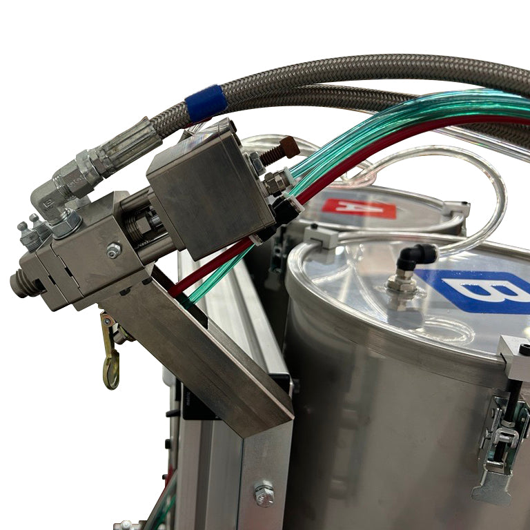 Close-up of the AST GMP 025 dispensing wand, showing metal fittings, braided hoses, and clear tubing.