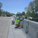 Contractors using AST RMP 317-C epoxy injection machine for concrete crack repair on a bridge