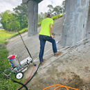 Man fixing concrete highway pillar with epoxy dispensing system